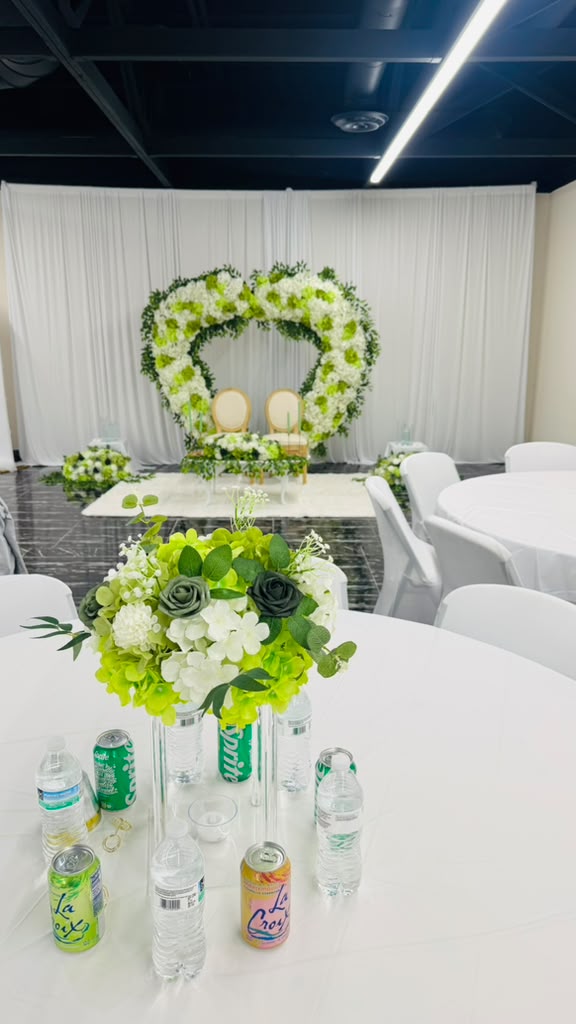 Green and white centerpiece in front of the heart arch