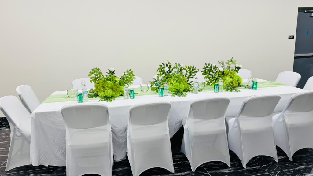 Long banquet tables in white with green floral runners